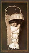 Old photo of  a baby wrapped in a cradleboard