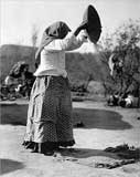 Old photo of a Papago woman cleaning wheat